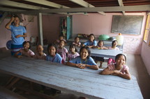 children sitting at desks in a school classrooml 