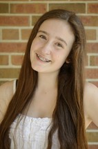face of a smiling teen girl with braces