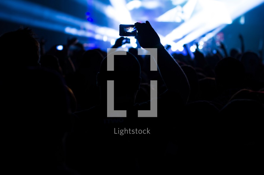 taking a picture with a cell phone at a concert