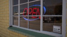 A lit-up Open sign in the window of a small business