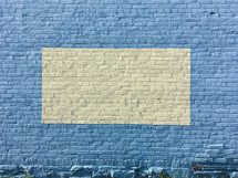 framed pale yellow on blue brick wall background 