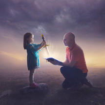 A little girl pulls a bright sword out of the Bible.