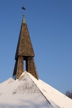 snow on a church roof and a steeple 