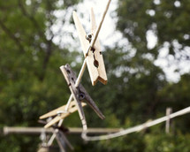 Wooden clothes pins on a laundry line outside.