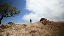woman standing at the top of a hill 