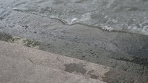 water lapping onto a concrete shore 