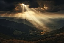 Sunset in the mountains with rays of light coming from the clouds