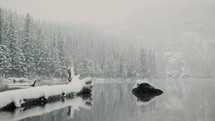 Beautiful lake in the mountains being covered with snowfall