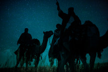wise men traveling on camels pointing up 