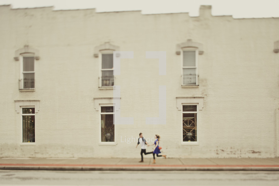 Couple running down sidewalk street