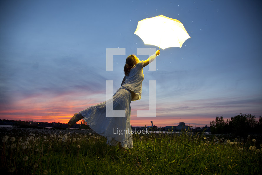 a woman holding an open umbrella and floating 