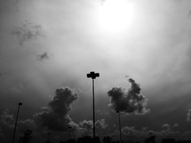 clouds in the sky and parking lot lamps 