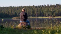 A man fishing on a peaceful lake in the morning