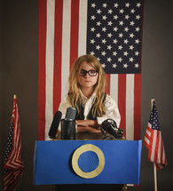 girl standing at a podium running for president 
