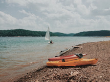 kayaks and sailboats on a lake 
