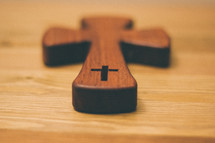 Wooden cross on a wood table.