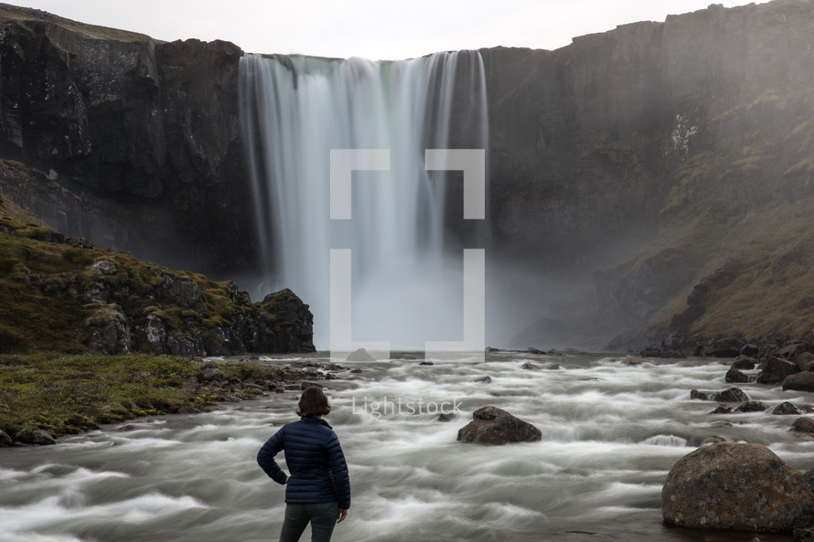 a woman watching a waterfall in Iceland 