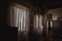 A woman looking out a window in a villa in Italy