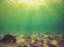 rays of sunlight shining under water 