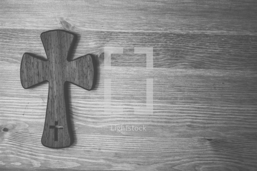 Wooden cross on a wood table.