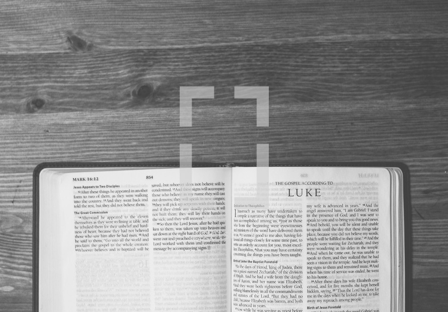 Bible open to Luke on a wooden table.