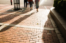 sunlight shining on a brick sidewalk 
