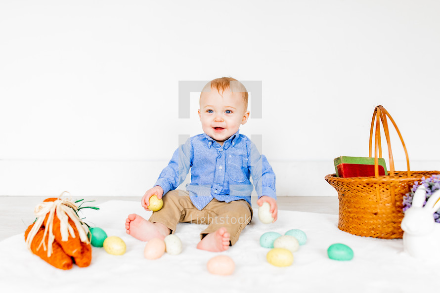 a portrait of a toddler boy with an Easter basket 