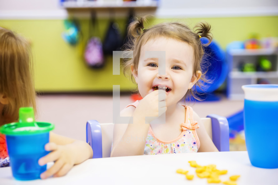 toddler eating a snack at preschool 