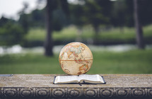 globe and open Bible outdoors 