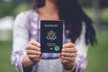 a woman holding a passport outdoors 