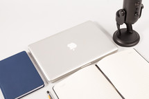 journal, notebook, headphones, microphone, and laptop computer on a white background 