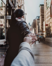 couple walking on a sidewalk holding hands 