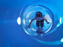 child crawling in a tunnel on a playground 