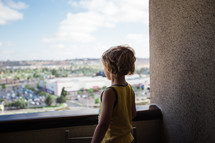 child looking over a balcony 