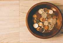 Coins in a wooden bowl.