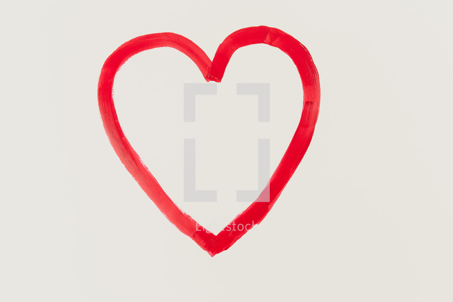 a red painted heart on white paper 
