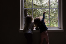 toddlers looking out a window 