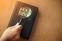 magnifying glass over a Bible 