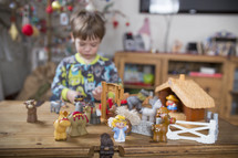 a child playing with a nativity scene toy 