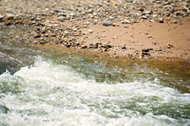rushing water and a peebles on the shore 