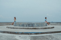 twins sitting on opposite sides on a concrete structure 
