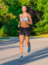 Girl Runs Through The Park In The Morning. Sporty Young Attractive woman