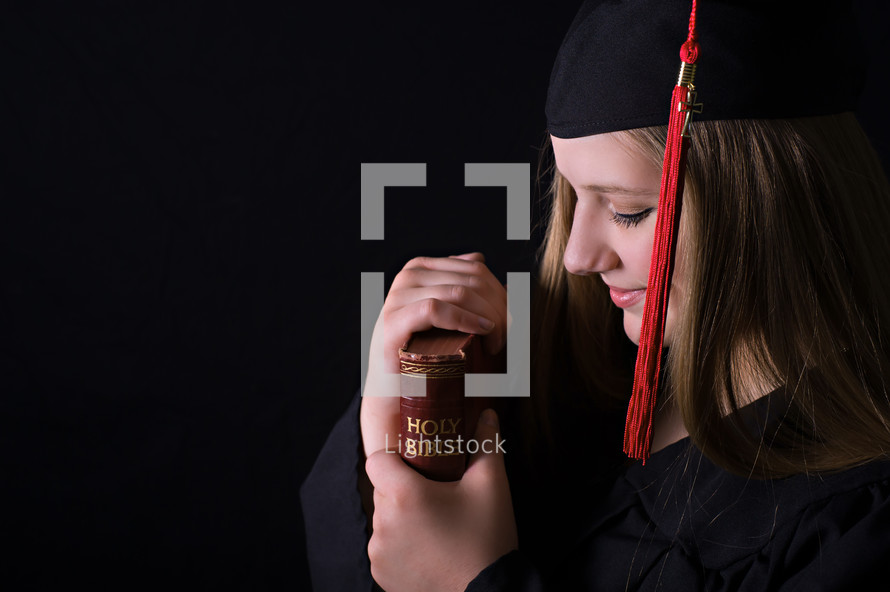 female graduate holding a Bible 