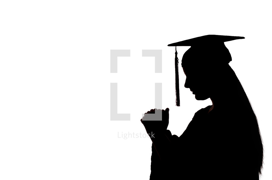 silhouette of a graduate in prayer 
