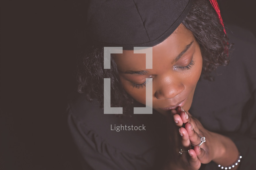 face of an African American graduate in prayer 
