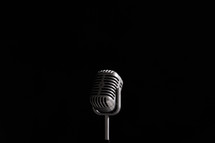 Vintage style microphone on black background. 