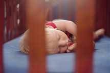 a toddler sleeping in a crib