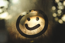 smiley face on fogged glass 