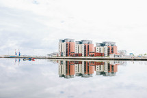 reflection of buildings on water in a marina 