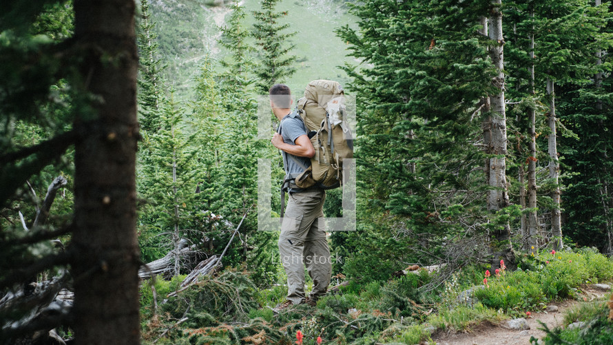 man backpacking through the woods 